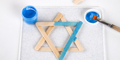 A star of david made of blue painted popsicle sticks